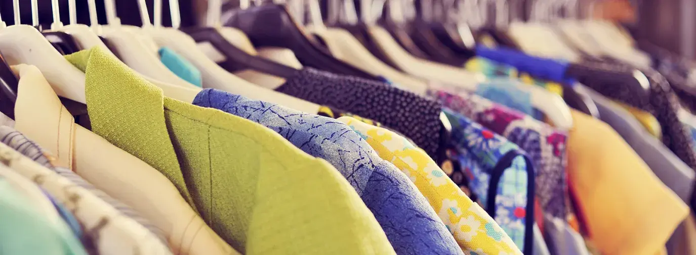 Image: rack of colorful clothing. Topic: Finding New Life for Old Clothes